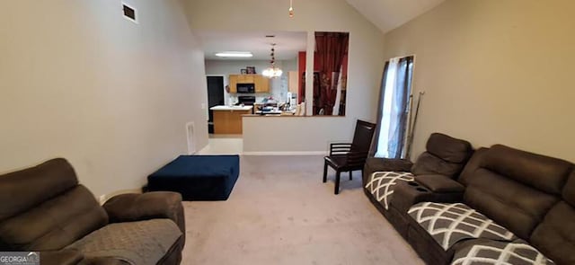 carpeted living room with high vaulted ceiling and an inviting chandelier