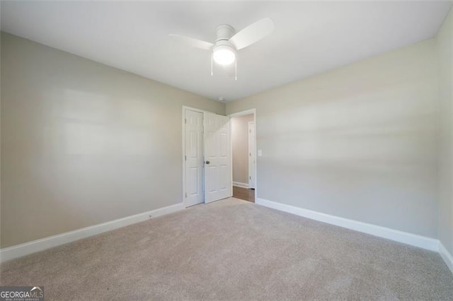 carpeted spare room featuring ceiling fan