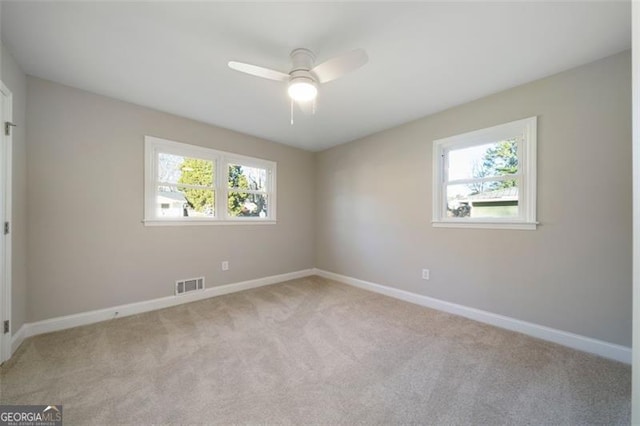 carpeted spare room with ceiling fan