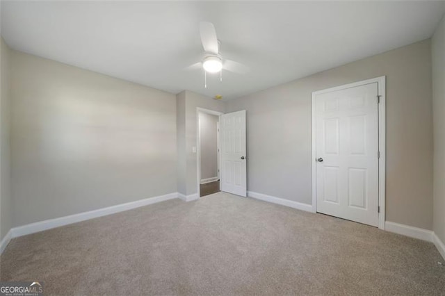 unfurnished bedroom featuring light colored carpet and ceiling fan