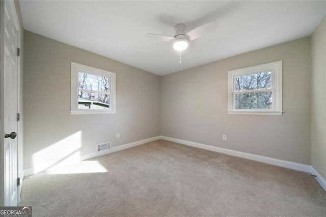 unfurnished room with light carpet, a wealth of natural light, and ceiling fan