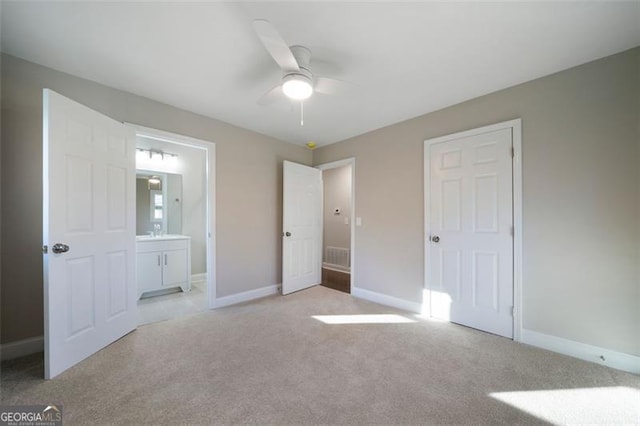 unfurnished bedroom with connected bathroom, ceiling fan, and light carpet