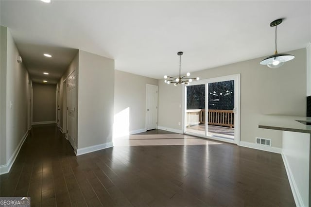 unfurnished dining area with dark hardwood / wood-style floors and an inviting chandelier