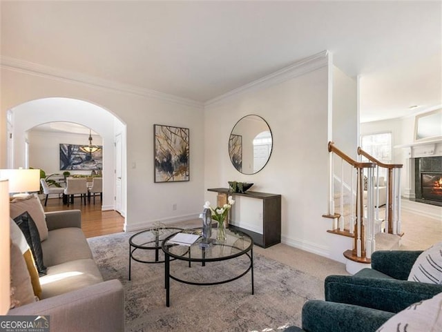 living room with light wood-type flooring, ornamental molding, and a premium fireplace