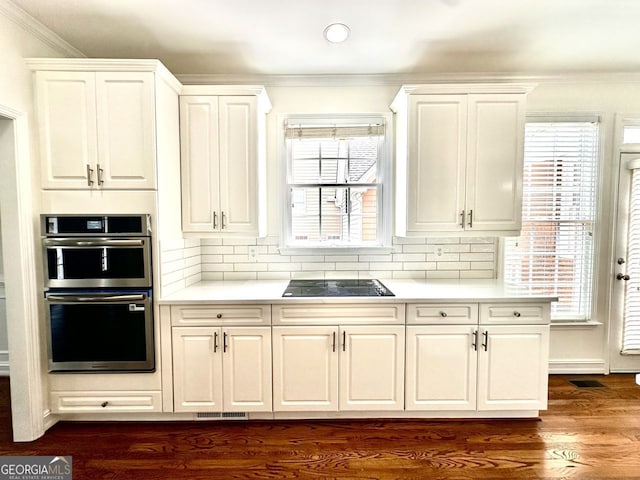 2750 Olde Towne Pkwy, Duluth, GA 30097 - kitchen with double oven, ornamental molding, light countertops, black electric stovetop, and white cabinets