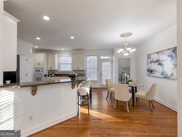 2750 Olde Towne Pkwy, Duluth, GA 30097 - kitchen with a breakfast bar, crown molding, white appliances, a chandelier, and washing machine and clothes dryer