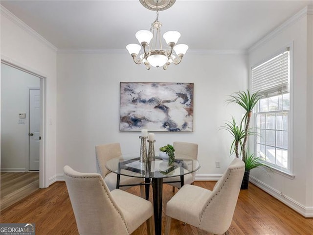 dining room with hardwood / wood-style flooring, a notable chandelier, and ornamental molding