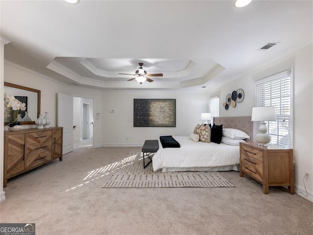 carpeted bedroom featuring a raised ceiling, ceiling fan, and ornamental molding