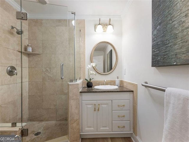 bathroom with walk in shower, vanity, and ornamental molding