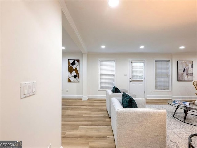 living room featuring light hardwood / wood-style flooring and ornamental molding