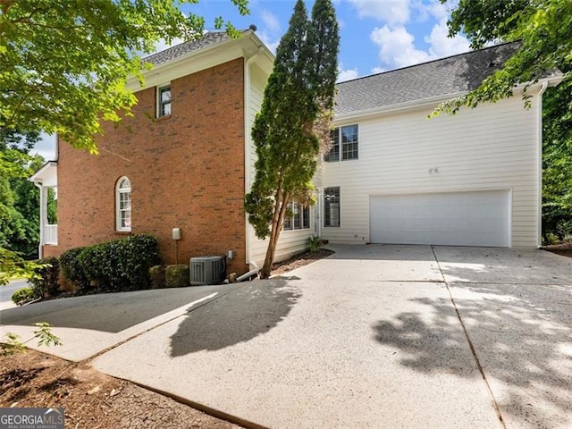 2750 Olde Towne Pkwy, Duluth, GA 30097 - view of front facade with a garage, concrete driveway, cooling unit, and brick siding