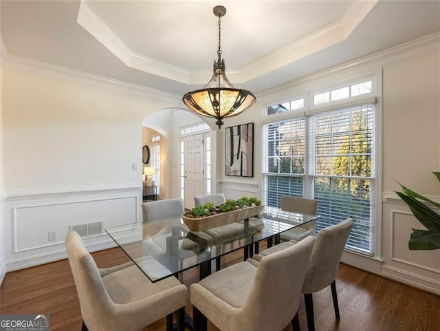 2750 Olde Towne Pkwy, Duluth, GA 30097 - dining room with a tray ceiling, a decorative wall, arched walkways, dark wood finished floors, and crown molding