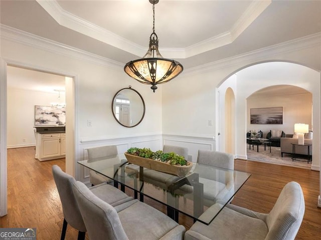 2750 Olde Towne Pkwy, Duluth, GA 30097 - dining area with arched walkways, a tray ceiling, wood finished floors, a chandelier, and wainscoting