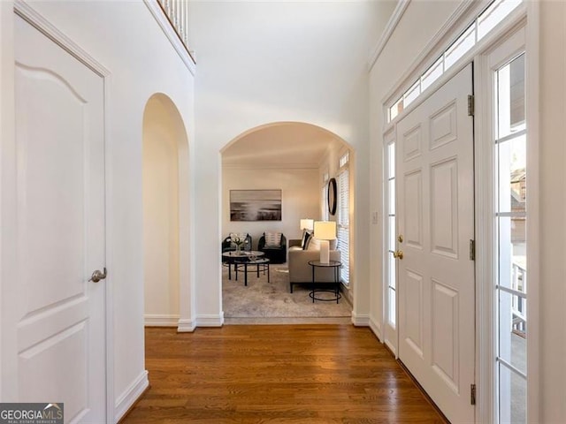 entryway with dark hardwood / wood-style floors and ornamental molding