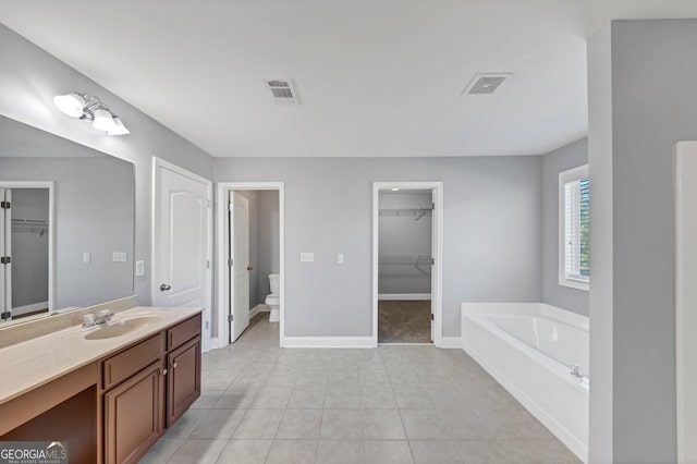 bathroom with tile patterned flooring, a bathtub, toilet, and vanity