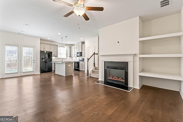 unfurnished living room featuring ceiling fan, dark hardwood / wood-style flooring, built in features, and sink