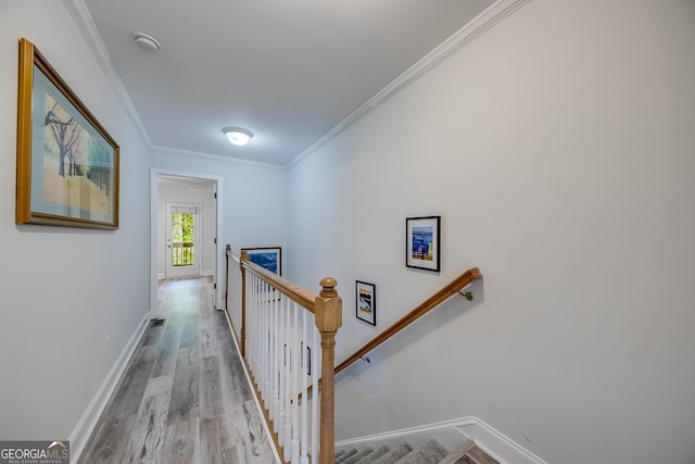 corridor featuring ornamental molding and light hardwood / wood-style floors