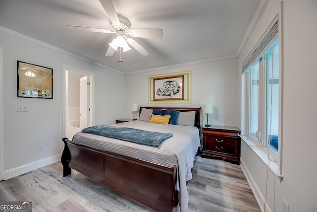 bedroom with light wood-type flooring, ceiling fan, multiple windows, and ensuite bath