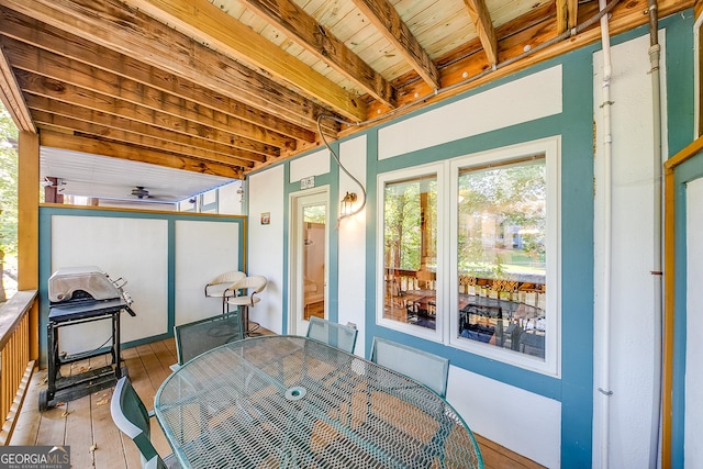 sunroom / solarium with beam ceiling and ceiling fan