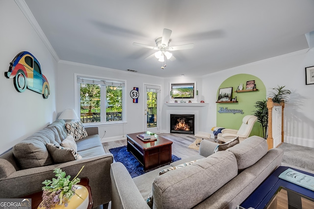 living room featuring ceiling fan, wood-type flooring, and ornamental molding