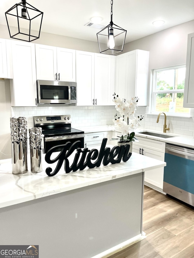 kitchen with white cabinets, appliances with stainless steel finishes, and sink