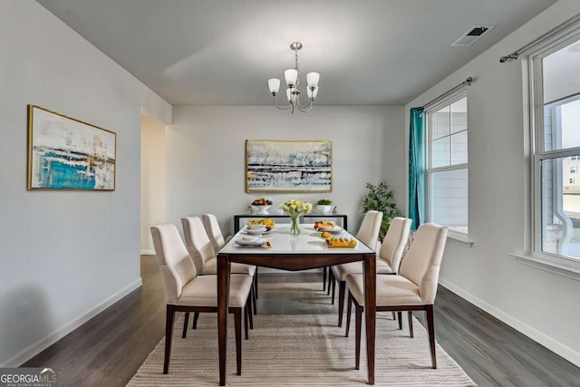 dining space featuring dark hardwood / wood-style floors and a notable chandelier