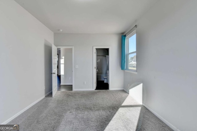 unfurnished bedroom featuring light carpet and ensuite bathroom