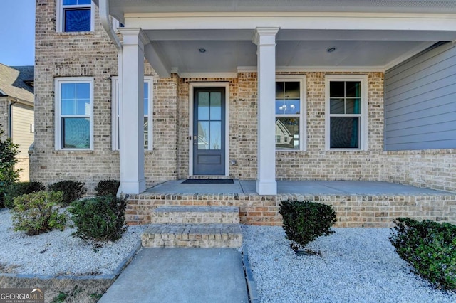 view of exterior entry featuring covered porch