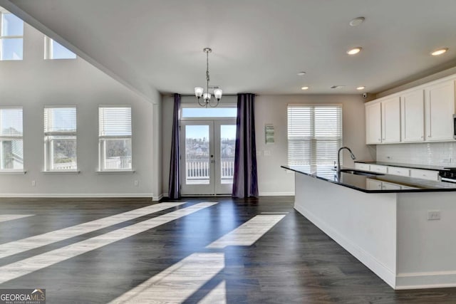 kitchen with dark hardwood / wood-style flooring, white cabinetry, hanging light fixtures, and sink