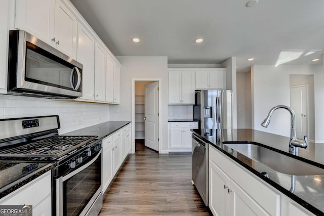 kitchen with white cabinets, appliances with stainless steel finishes, dark hardwood / wood-style floors, and sink