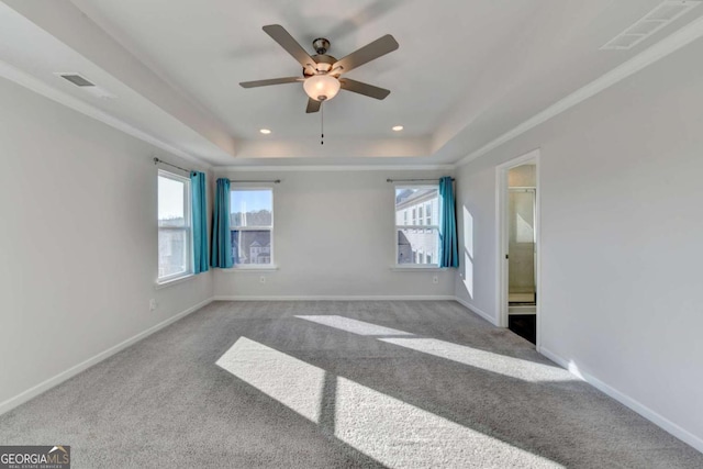 carpeted spare room with a raised ceiling, ceiling fan, and crown molding