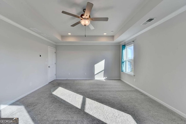 carpeted spare room with a raised ceiling, ceiling fan, and ornamental molding