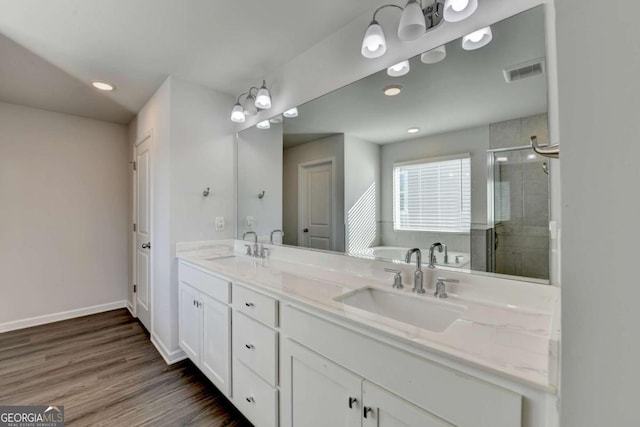 bathroom featuring vanity, wood-type flooring, and shower with separate bathtub