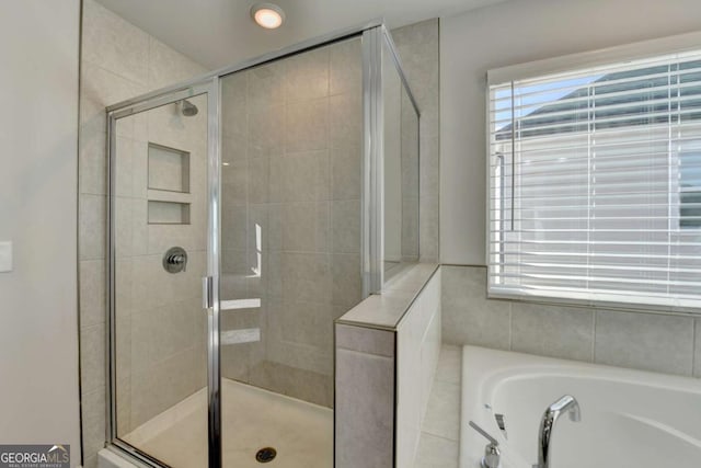 bathroom featuring shower with separate bathtub and a wealth of natural light