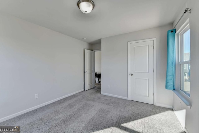 unfurnished bedroom with light colored carpet and multiple windows