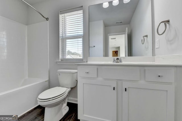 full bathroom with hardwood / wood-style floors, vanity, toilet, and shower / washtub combination