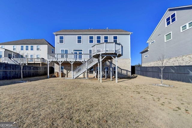 rear view of house with a deck and a yard