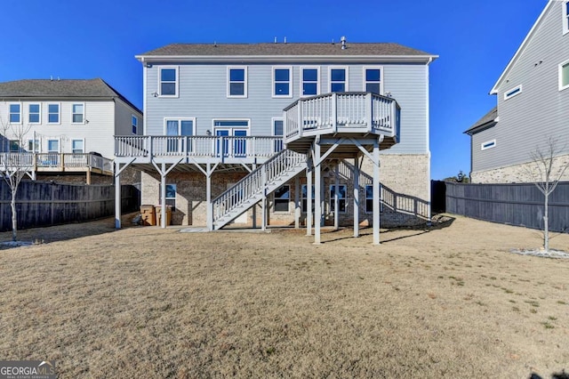 rear view of property featuring a lawn and a wooden deck