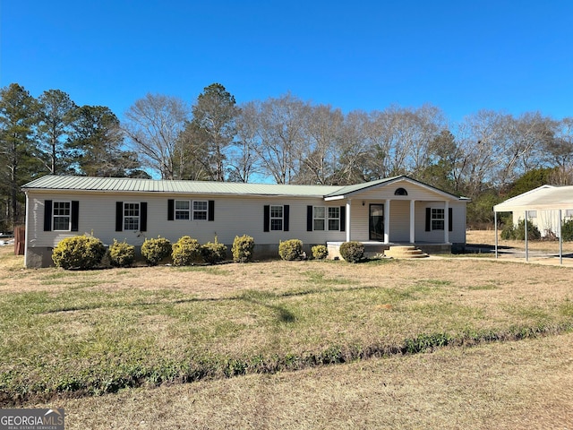 ranch-style home with covered porch, a front yard, and a carport