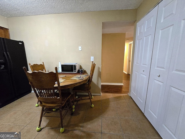 tiled dining space with a textured ceiling