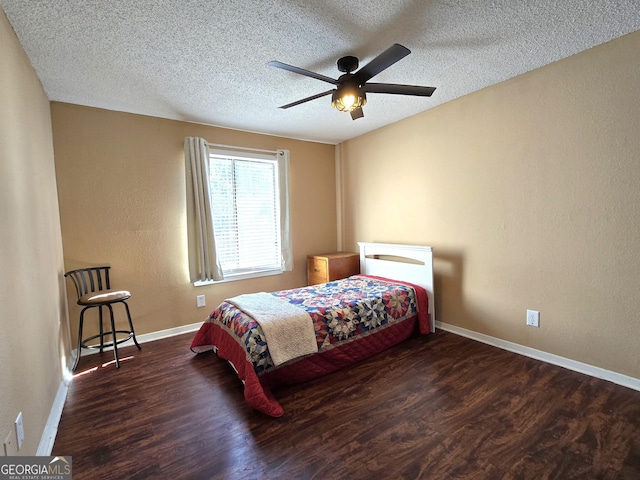 bedroom featuring dark wood-type flooring, ceiling fan, and a textured ceiling