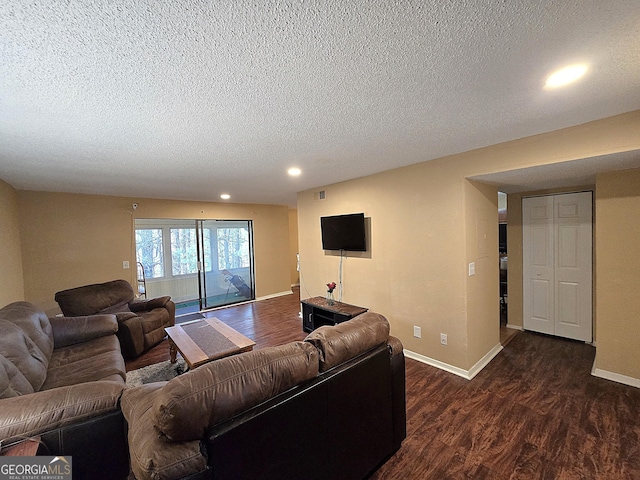 living room featuring a textured ceiling and dark hardwood / wood-style flooring