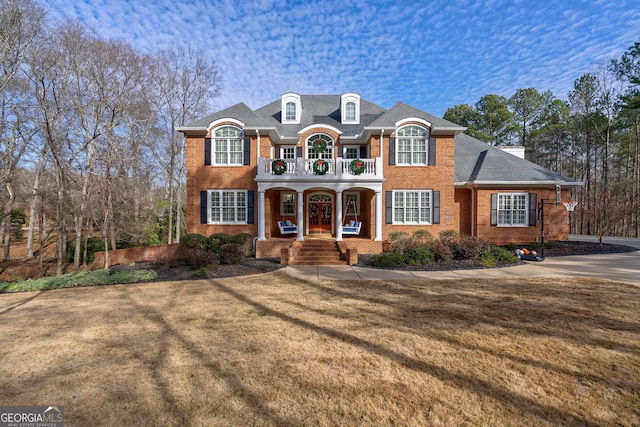 french country style house featuring a porch and a front yard