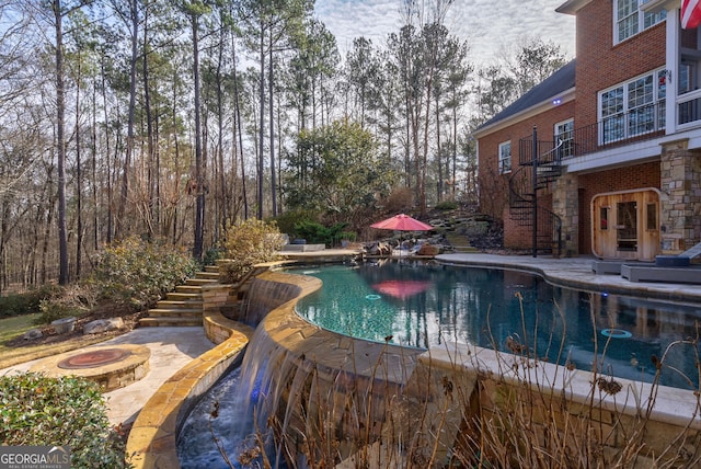 view of pool with a fire pit and a patio area