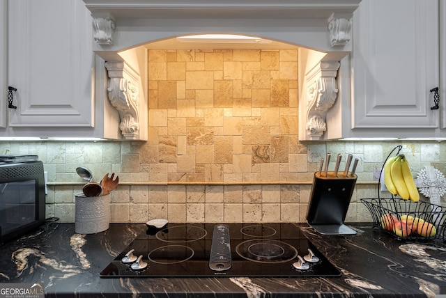 kitchen with white cabinets, backsplash, and black electric cooktop