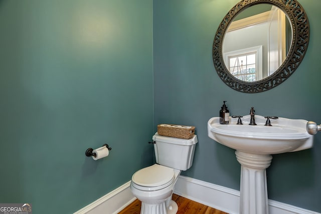 bathroom with hardwood / wood-style flooring and toilet