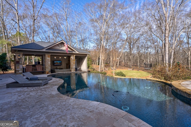 view of swimming pool featuring a patio and exterior fireplace