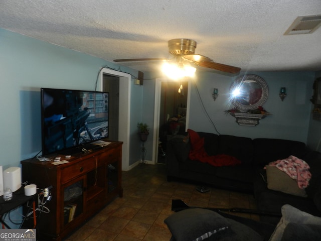 living room featuring ceiling fan and a textured ceiling