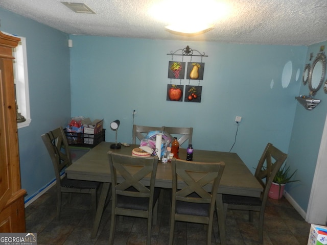 dining space with a textured ceiling