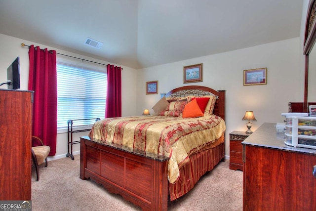 bedroom with light colored carpet and lofted ceiling